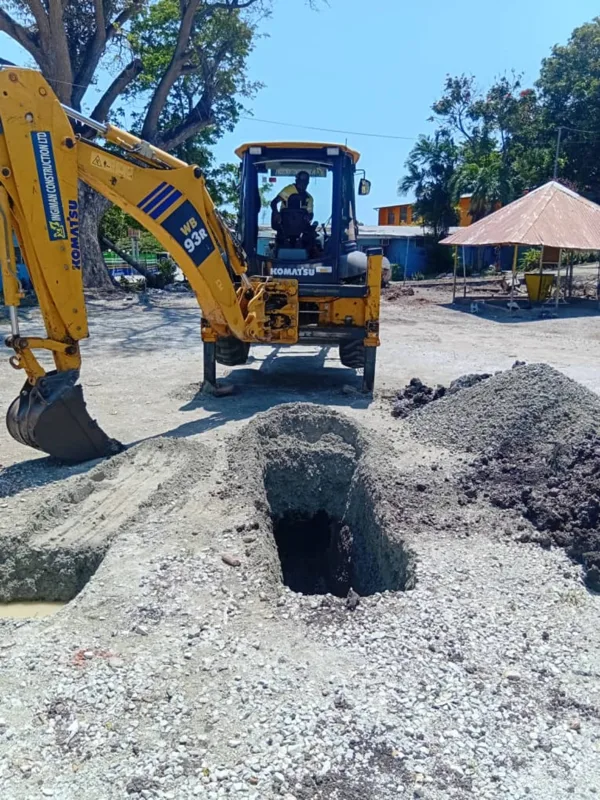 Excavator beside an open test pit