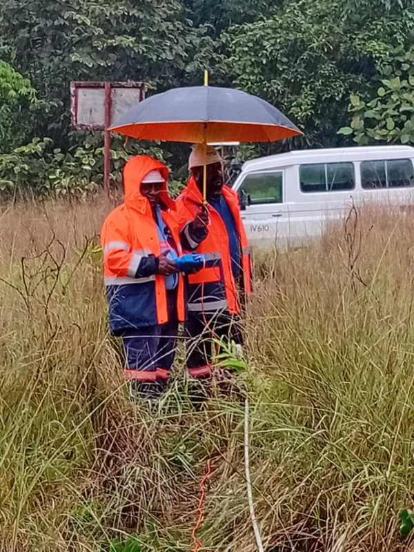 Survey equipment in use beneath a field umbrella